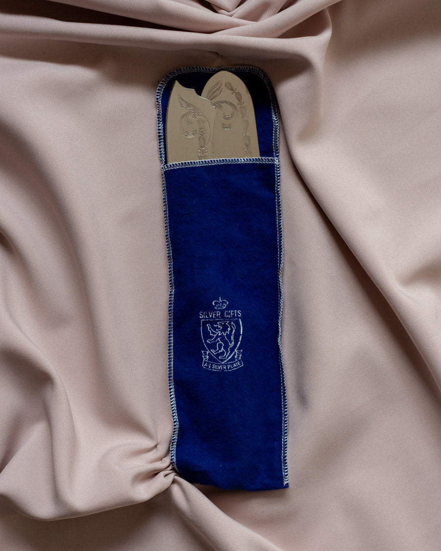 Sidabru dengti torto įrankiai mėlyname maišelyje