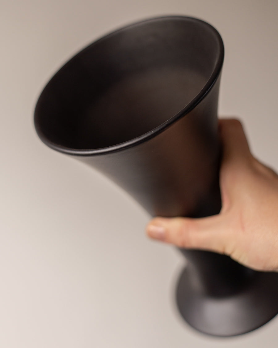 Į viršų platėjanti juoda keramikinė vaza